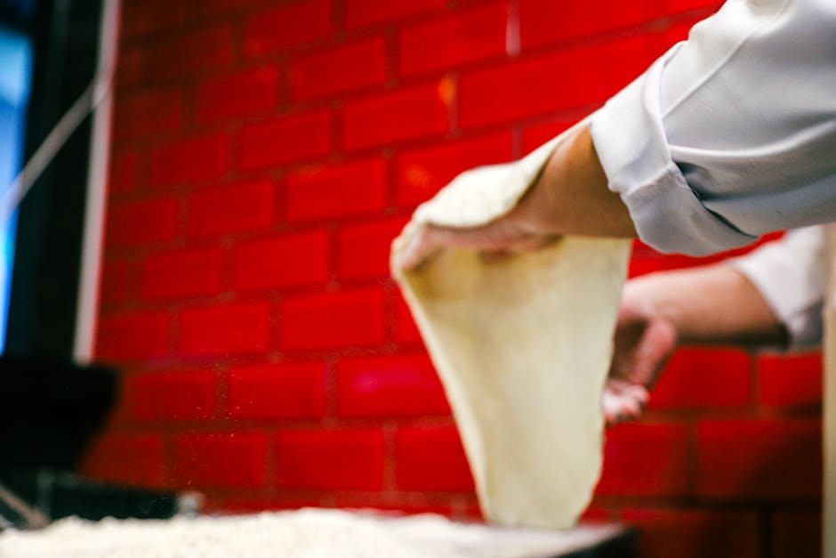 Pâte à pizza en cours de pétrissage sur le plan de travail